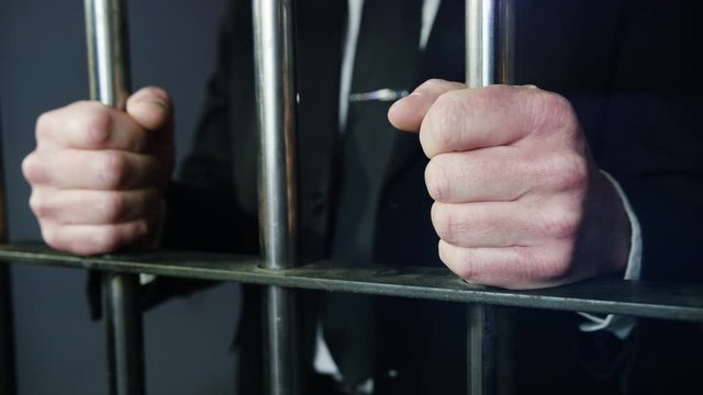 White collar criminal in jail behind bars
