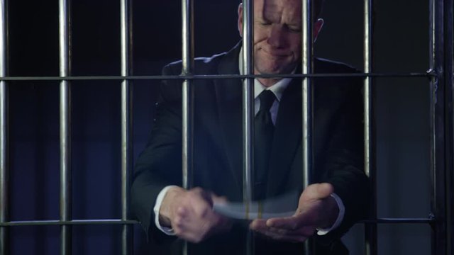 White collar criminal in jail behind bars