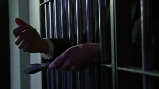 White collar criminal in jail behind bars