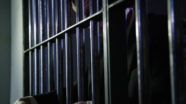 White collar criminal in jail behind bars