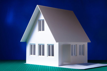 Model house with white walls. Two-storey cottage on a dark background. Architectural concept. Individual project of the building. The layout of the premises in the future house. The layout of housing