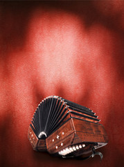 Bandoneon, three quarters view on dark red background