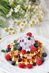 waffles with blueberries and raspberries and berry ice cream from yogurt.