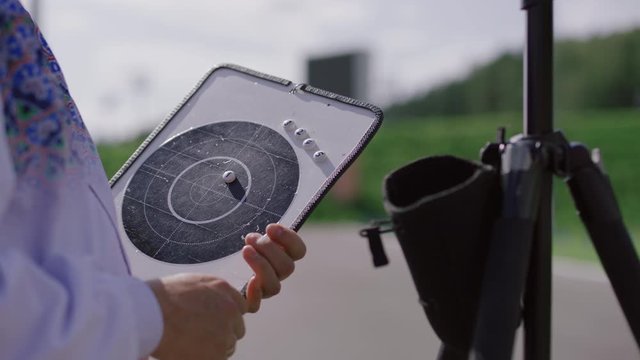 CU Caucasian coach trainer marking target hits on a board, biathlon practice on a shooting in summer. ARRI Alexa Mini with Cooke S4 prime lenses RAW graded footage