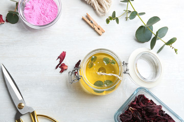 Flat lay composition with homemade candle in glass jar on light table