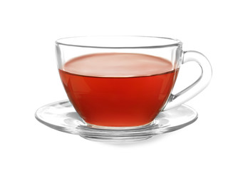 Glass cup of tea and saucer on white background