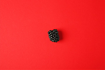 Tasty ripe blackberry on red background, top view