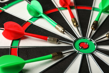 Red and green arrows on dart board, closeup