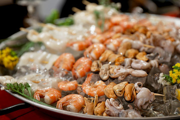 Seafood skewers served in dish with ice, closeup