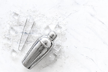 ice cubes and shaker on white marble table top view mock up