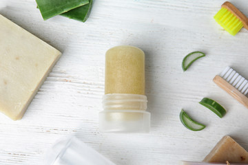 Flat lay composition with natural crystal alum deodorant on white wooden table