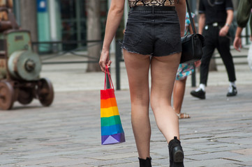 Closeup of mini jeans short on lesbian girl and rainbow bag  in the street