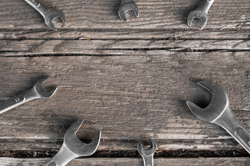 Chrome wrenches on wooden background with copy space, concept of repair and construction