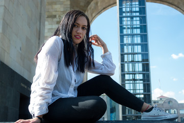 Mujer sentada en banca de ciudad