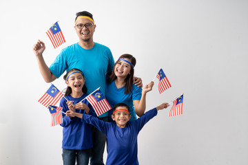 proud malaysian family holding malaysia flag over white background on independence day