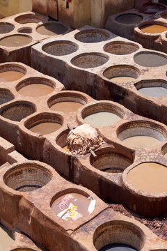 Stone vessels filled with a vast range of dyes in leather tanneries of Fez in Morocco.