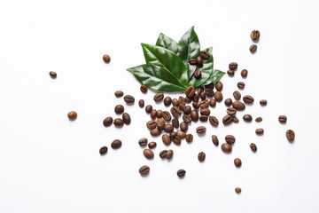 Fresh green coffee leaves and beans on white background, top view