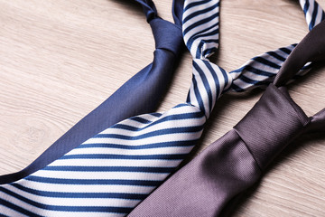 Different stylish neckties on wooden table, closeup