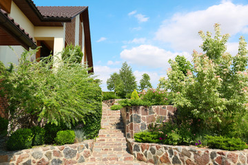 Landscape with modern house and beautiful garden on sunny day