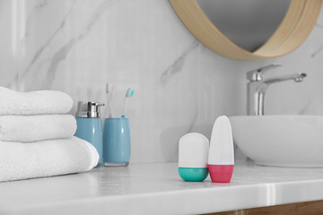 Obraz na płótnie Canvas Different deodorants on light countertop in bathroom