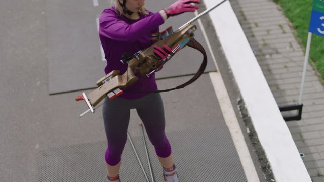 Portrait of Caucasian female professional biathlete practicing on a shooting range during mid-season practice in summer. ARRI Alexa Mini with Cooke S4 prime lenses RAW graded footage