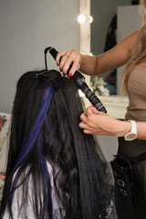 Fototapeta premium Hairdresser makes hairstyle to client. Hairdressing services. Creating hairstyle. Hair styling process. Beauty service concept