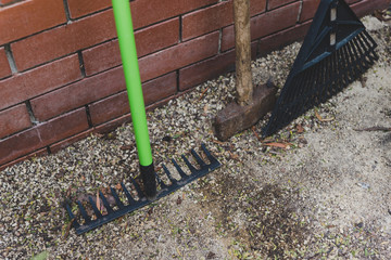rakes and hammer next to brick wall