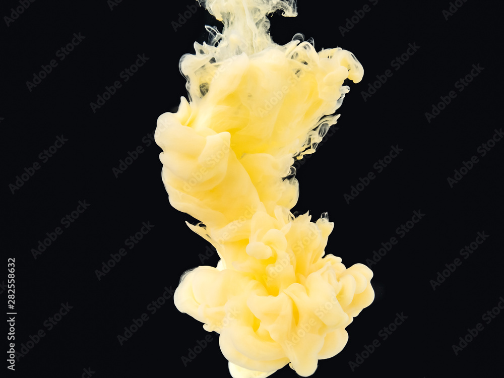 Poster cloud of yellow-white ink mixing with liquid, isolated on black background, close up view. drop of p