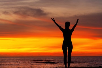 Fototapeta na wymiar strong confidence woman open arms under the sunrise at seaside