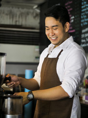 Happy Asian barista man working in cafe, lifestyle concept.