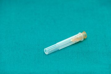 Injection needle with cover isolated on surgical green drape