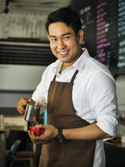 Happy Asian barista man working in cafe, lifestyle concept.