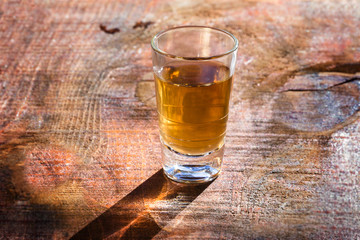 Several glasses of brazilian cachaça isolated on rustic wooden background, variations and types of...