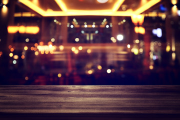 background Image of wooden table in front of abstract blurred restaurant lights