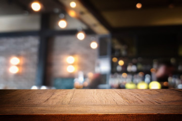 background Image of wooden table in front of abstract blurred restaurant lights