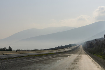 Empty road with foggy mountains.