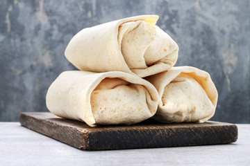 A burrito - mexican dish that consists of a flour tortilla with various ingredients.