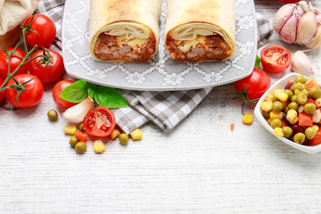 A burrito - mexican dish that consists of a flour tortilla with various ingredients.