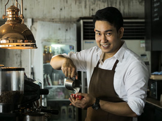 Happy Asian barista man working in cafe, lifestyle concept.