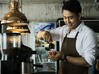 Happy Asian barista man working in cafe, lifestyle concept.