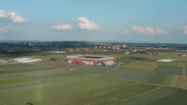 Drone / Aerial shot of the football stadium of the bundesliga team FSV Mainz 05 with field in the foreground on a sunny day, 25p
