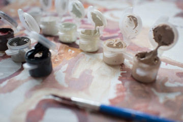 colored paint with a brush of the artist on the background of the painting
