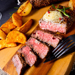 rustic medium butter beef steak with herbs and potato wedges