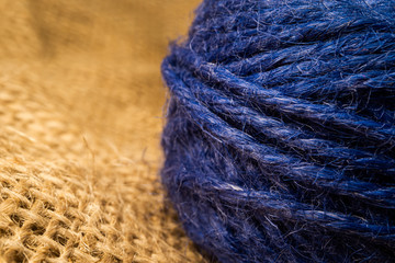 Wrapped blue rope isolated on natural linen fabric. Macro shooting.
