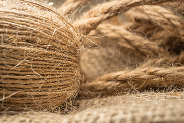 Macro view with natural jute twine roll isolated on natural linen fabric