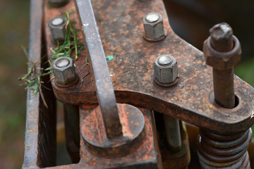 Old rusty nuts and bolt joint on fragment of partially old machine