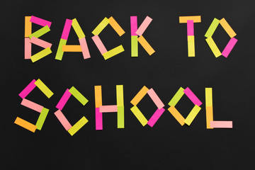 The inscription Back to school from the colored stickers on the blackboard.