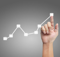 Hand touching graphs of financial indicator