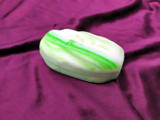 Obraz na płótnie Canvas white and green bathing soap on silk cloth