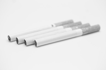 cigarettes stacked on a white background black and white photography 